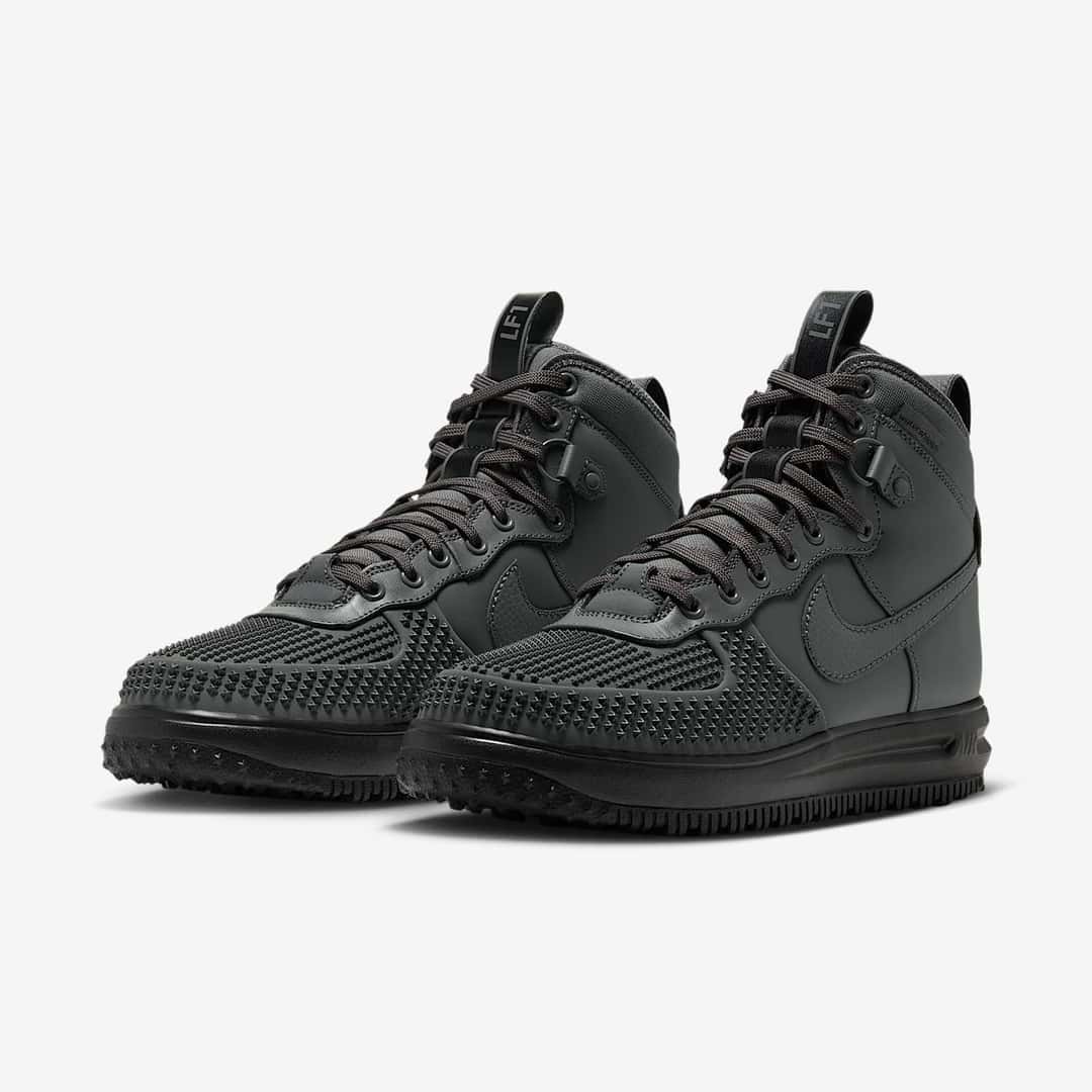 Par de Nike Lunar Force 1 Duckboot Iron Grey en vista diagonal, con caña alta gris oscuro, cordones grises y suela negra
