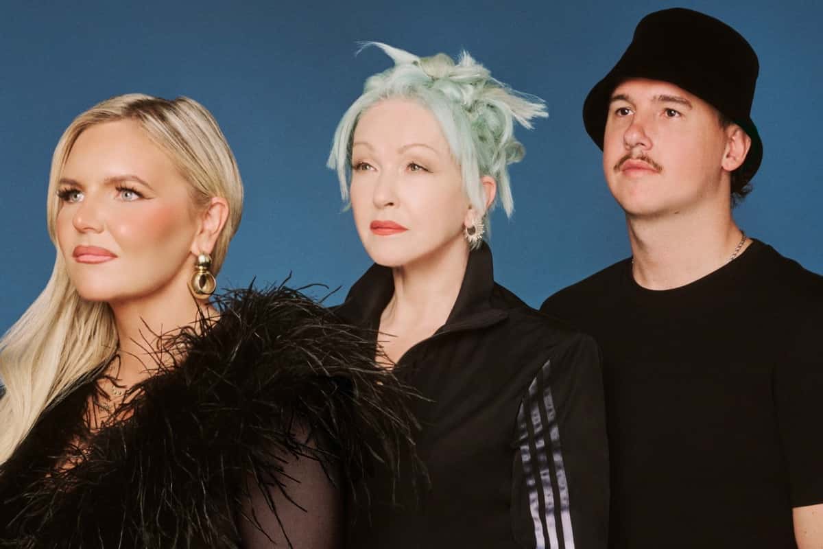 Tones And I, Cyndi Lauper y CYRIL posan juntos de negro sobre un fondo azul, en la foto oficial de prensa de «Time After Time»