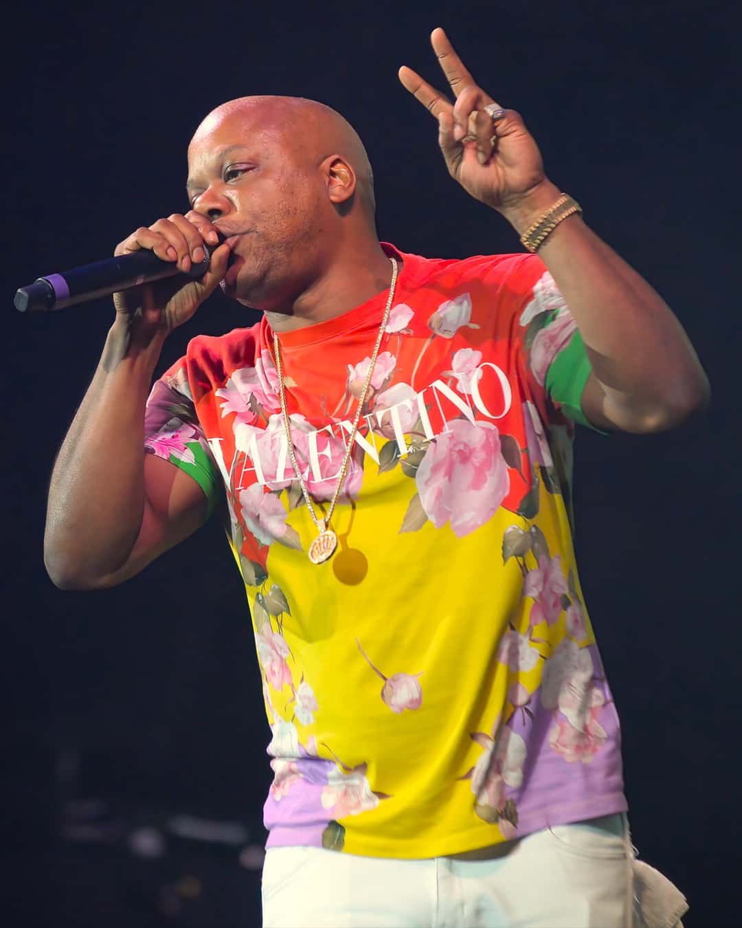 Too Short canta con el micrófono en la mano y hace la V con los dedos, con una remera de flores amarilla, roja y violeta, en un show de 2023 (foto de archivo). Foto: Rickmunroe01, CC BY-SA 4.0, vía Wikimedia Commons