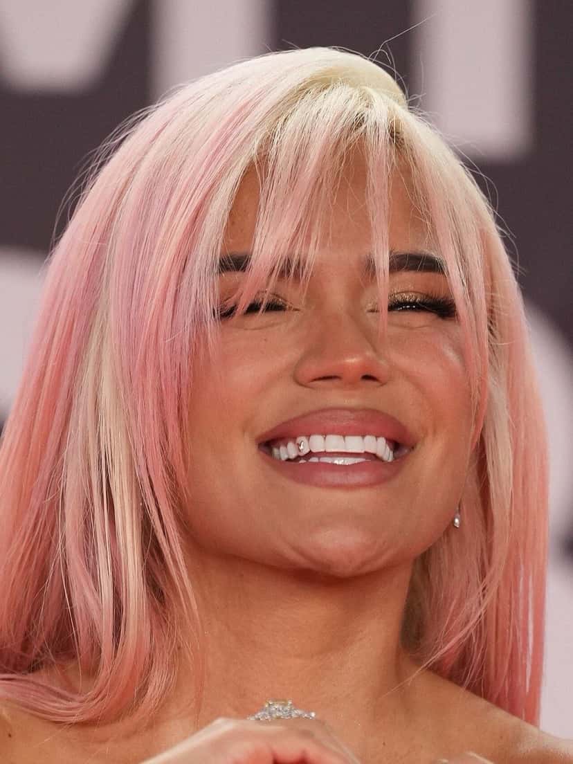 Karol G en la alfombra roja de los Latin Grammy 2023 en Sevilla, con el pelo rosa y flequillo, sonriendo (foto de archivo). Foto: Junta de Andalucía, CC BY-SA 2.0, vía Wikimedia Commons