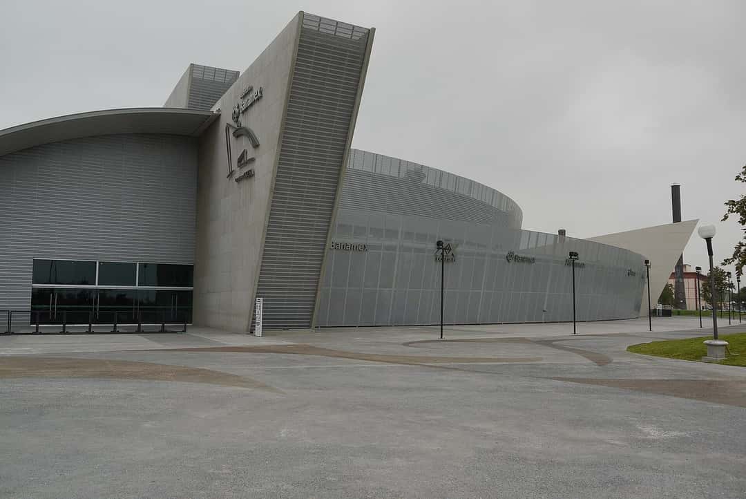 El Auditorio Banamex de Monterrey visto desde afuera, con su fachada gris de formas curvas y una explanada vacía, en un día nublado (foto de archivo, octubre de 2013). Foto: JavierDo, CC BY-SA 3.0, vía Wikimedia Commons