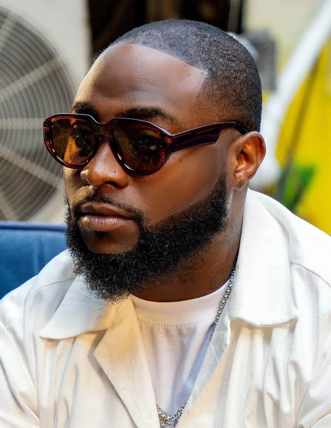 Davido, con anteojos de sol marrones, camisa blanca y cadena plateada, en una foto de 2024 (foto de archivo)