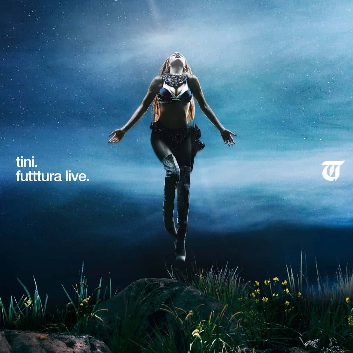 Portada de «Futttura Live», de TINI: la cantante flota en el aire con los brazos abiertos sobre un pasto con flores, bajo un cielo nocturno azul