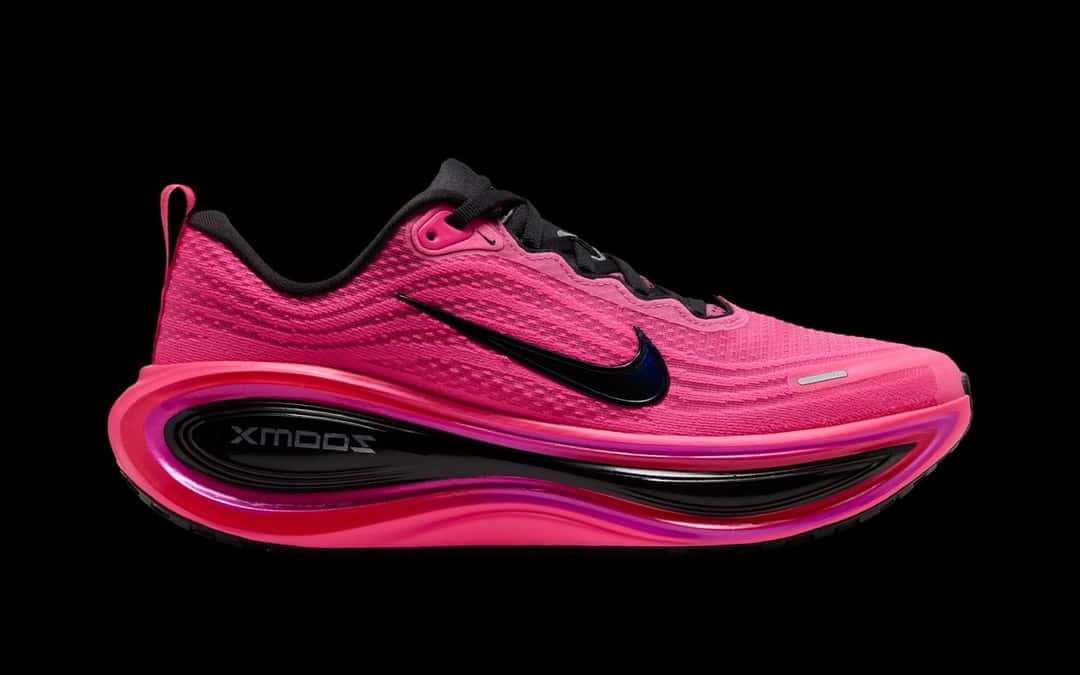 Nike Vomero Plus de la colección After Dark Tour de perfil, en rosa Hyper Pink con detalles negros y la entresuela rosa, sobre fondo negro