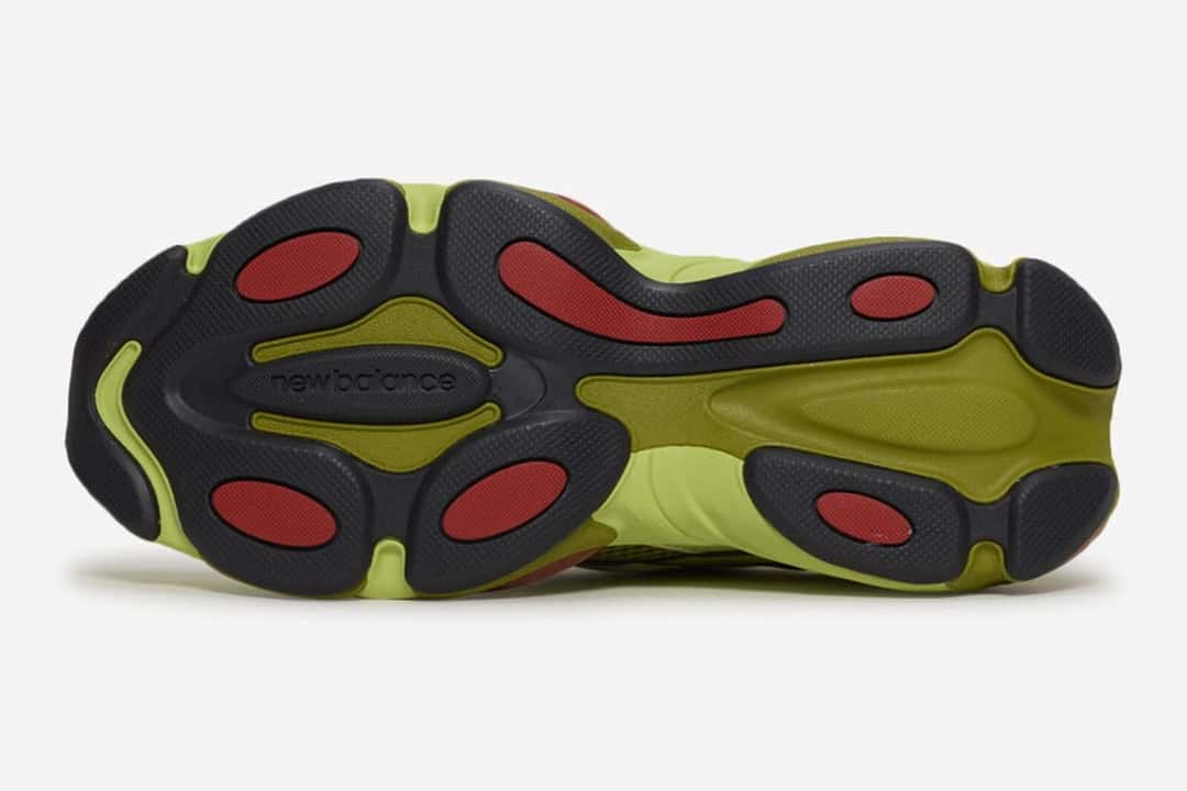 Suela del New Balance 983 Field Green Fennel Seed vista desde abajo, con las zonas negras, el verde claro y los pods rojos