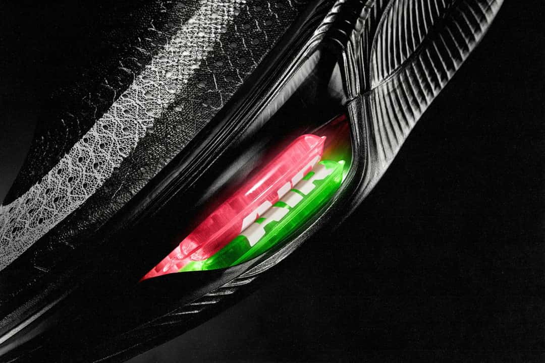 Primer plano del antepié de la Nike Apex negra con el doble Air Zoom a la vista: una unidad roja apilada sobre una verde, con la palabra AIR en blanco