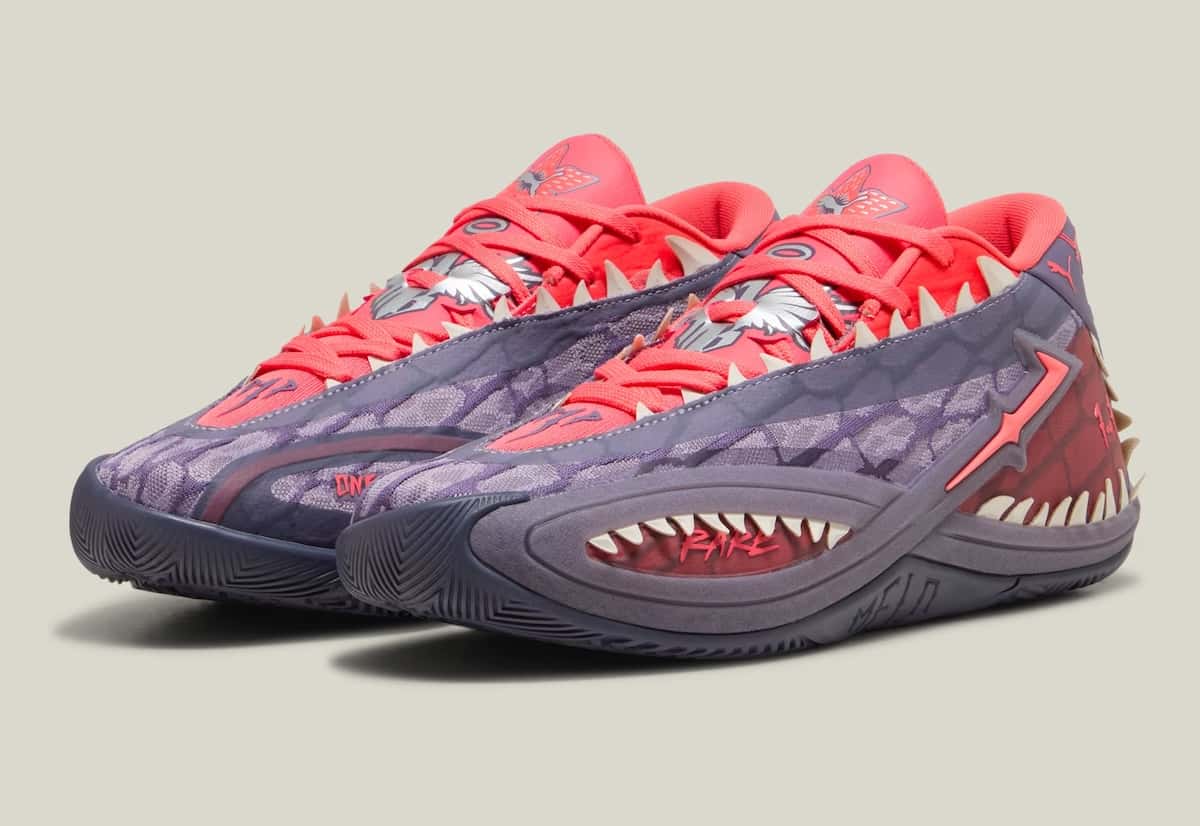 Par de PUMA MB.06 Stranger Things sobre fondo gris claro, con upper violeta texturado, lengüeta y cordones rojo coral, y una boca de dientes blancos que recorre la mediasuela con la palabra Rare en rojo