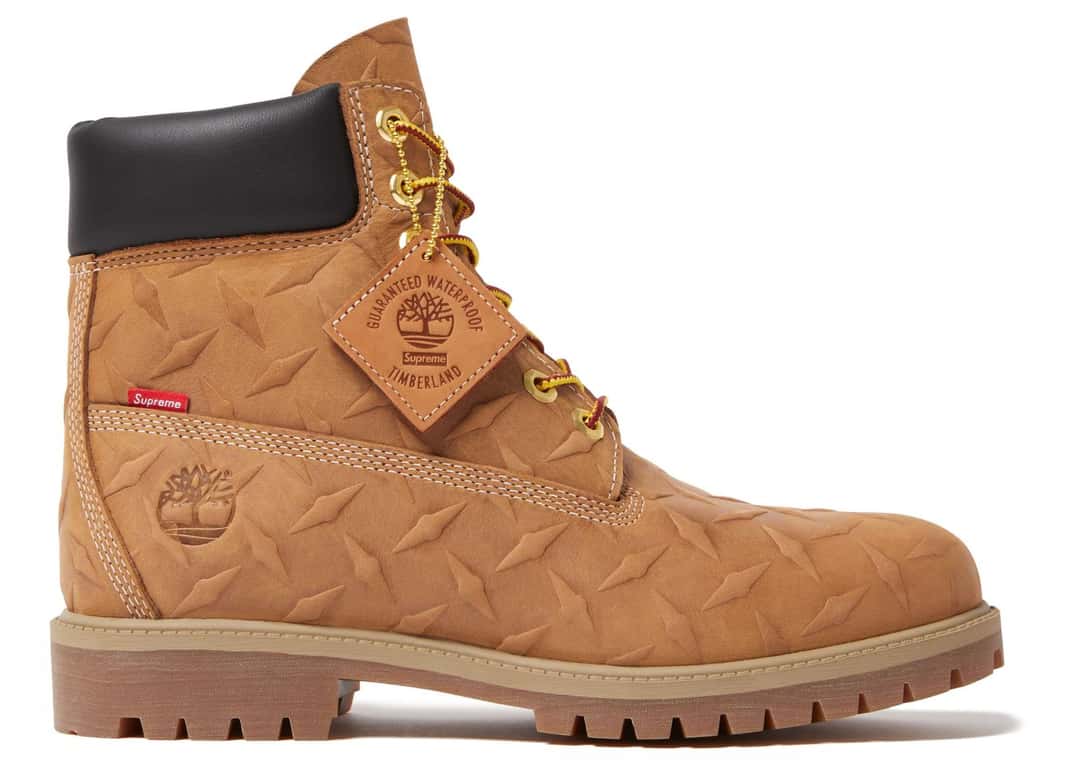 Vista lateral de la Supreme x Timberland Diamond Plate 6-Inch Wheat con ojales dorados, etiqueta colgante co-branded y árbol grabado en el talón