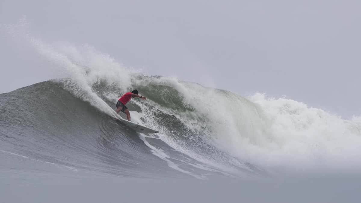 Joshua Moniz, con lycra roja, baja una pared de ola de Sunset Beach entre la espuma, bajo un cielo gris, el martes 27 de octubre en el HTA Sunset Pro 2026