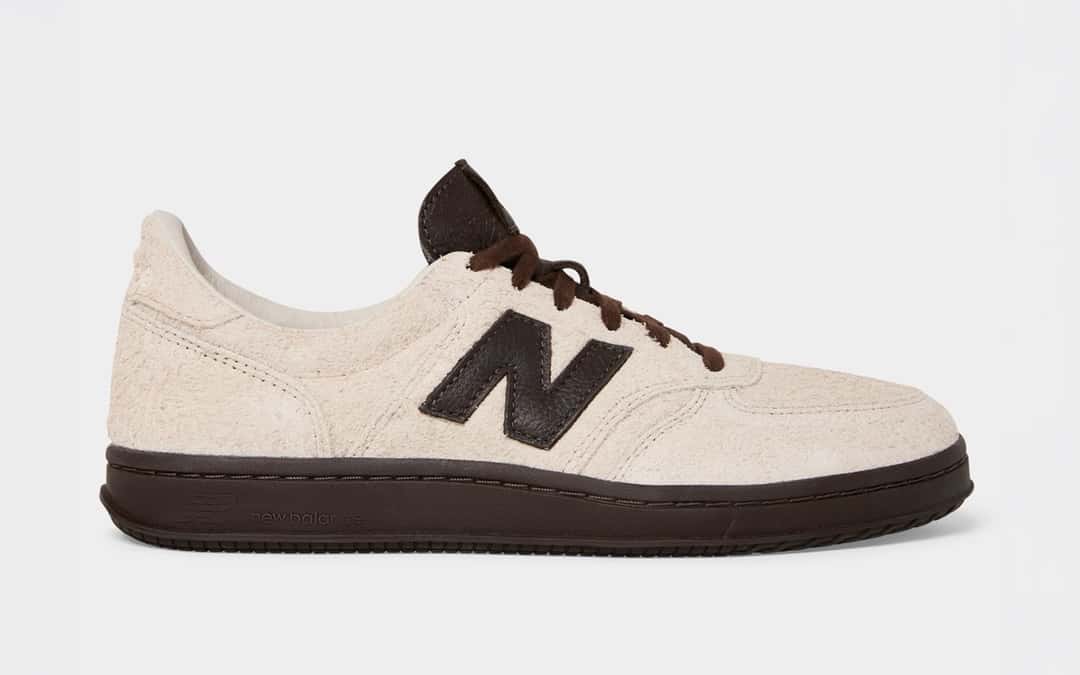 New Balance T500 Milk de Todd Snyder de perfil sobre fondo gris claro, en gamuza color crudo de pelo largo, con la N y los cordones en marrón oscuro y suela de goma marrón oscura