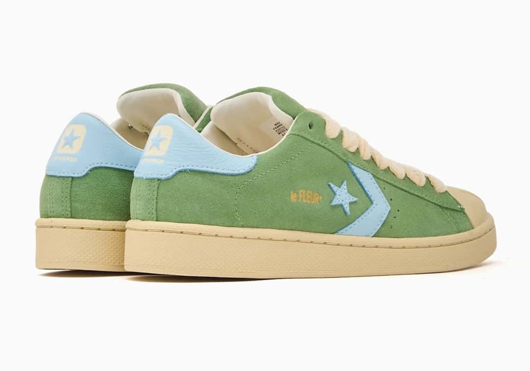 Par de la Converse Pro Leather de GOLF le FLEUR* en verde visto desde atrás en diagonal, con el talón celeste con la estrella, el logo le FLEUR* dorado al costado y la suela crema