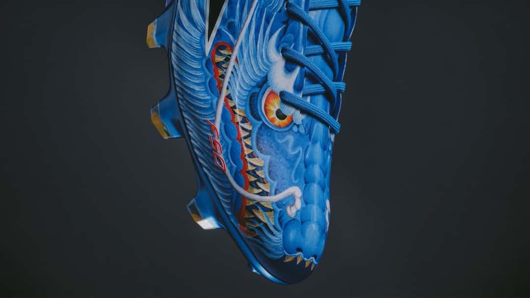Detalle de la adidas F50 Y-3 azul con un dragón dibujado en la capellada y cordones celestes