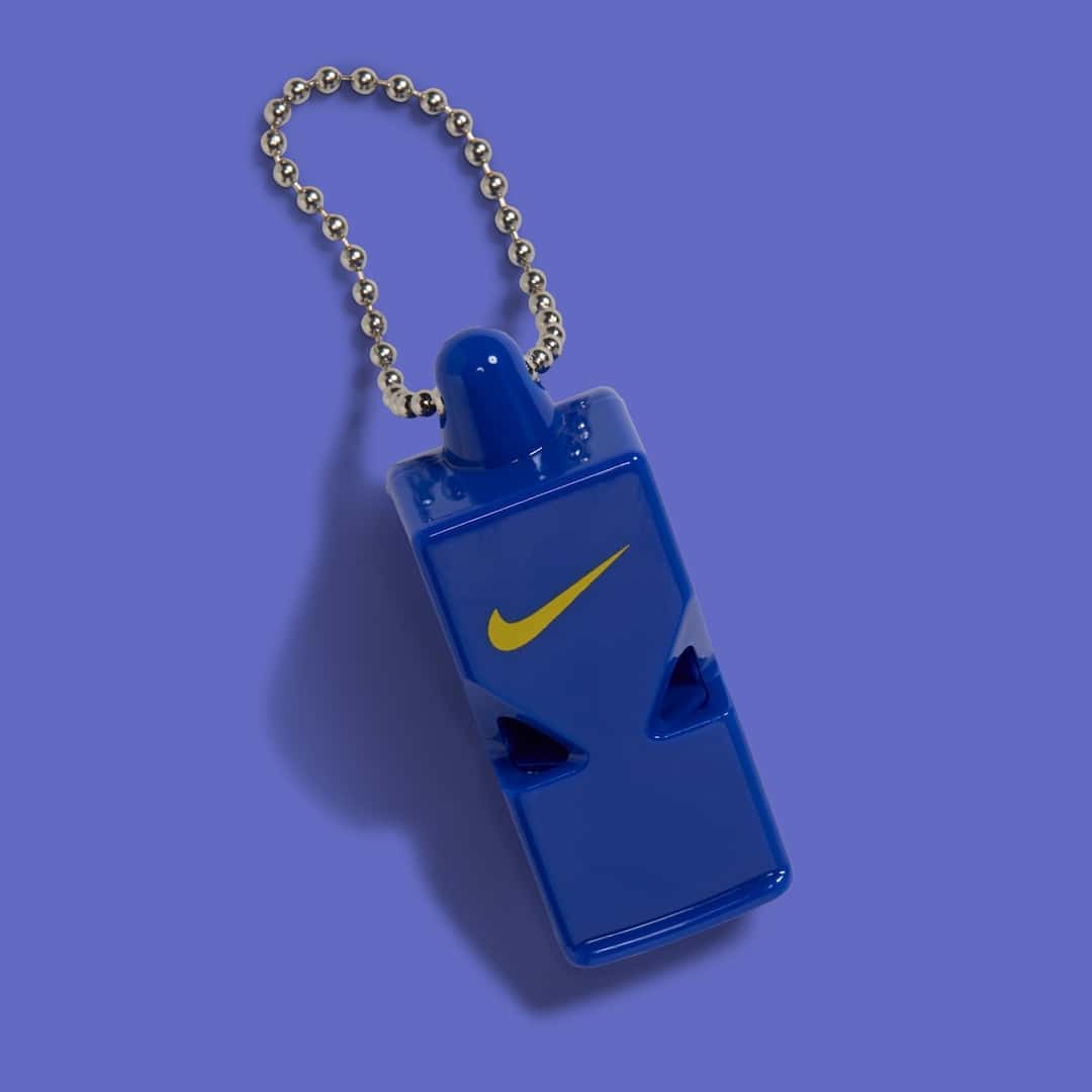 Silbato azul de plástico con el Swoosh dorado y una cadena de bolitas, el colgante de la Nike Air Max 97 Yardrunners de Coppin State