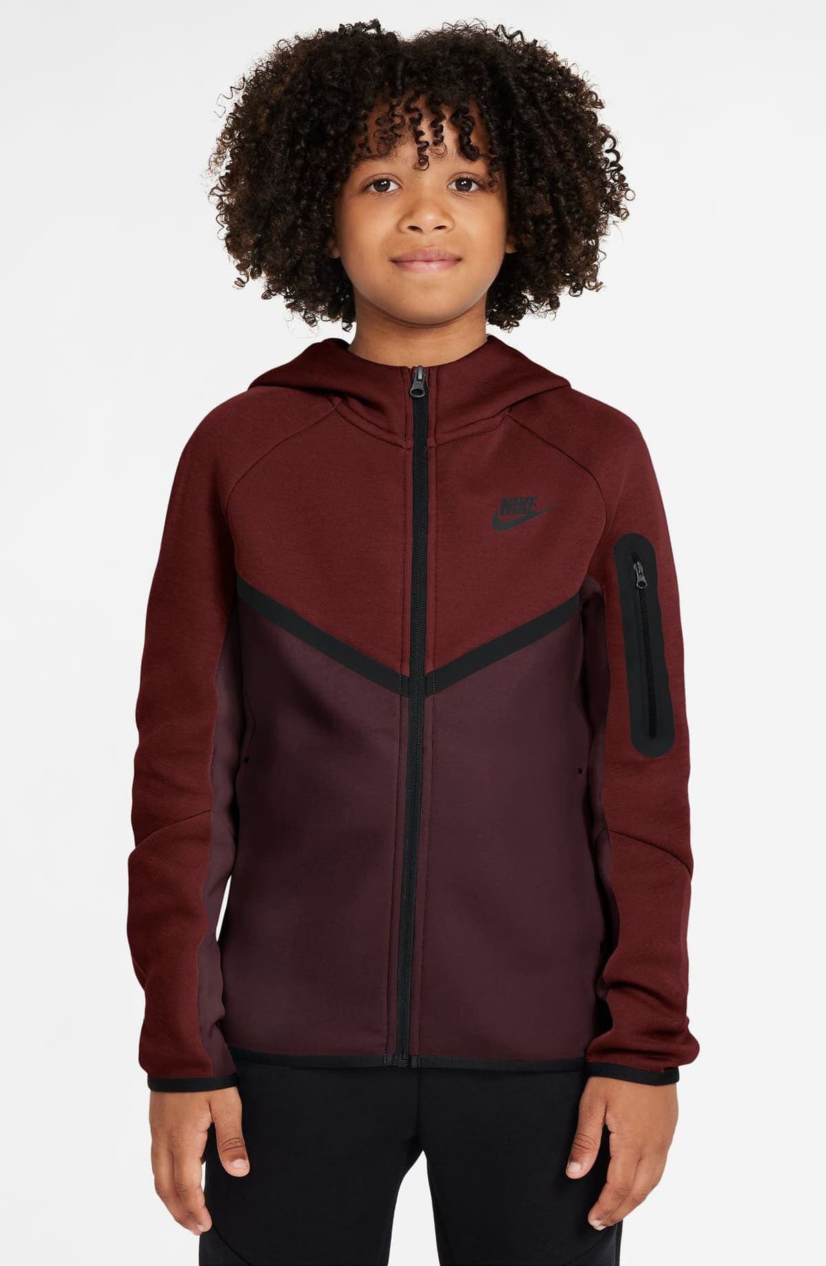 Niño con chaqueta Nike Tech Fleece con capucha en rojo y burdeos, cierre negro, chevron negro al frente y bolsillo con cierre en la manga